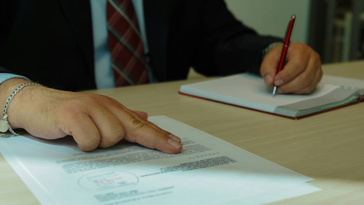Legal team reviewing documents with invoice labeled 'patent defense legal motion costs'